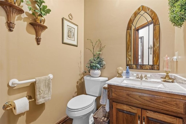 half bath featuring vanity and toilet