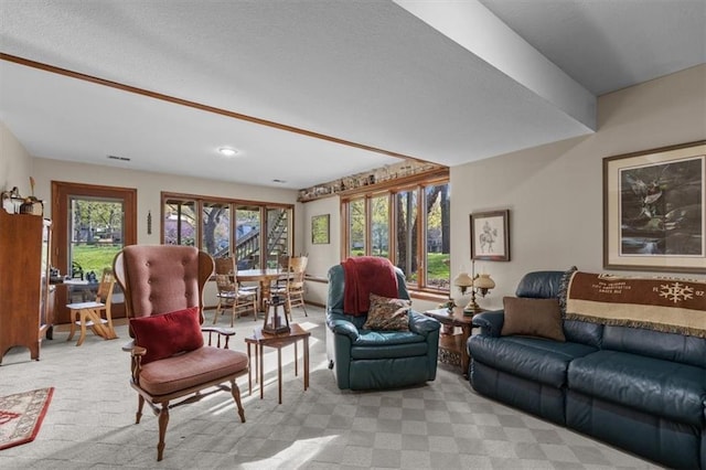 living area with visible vents and light carpet