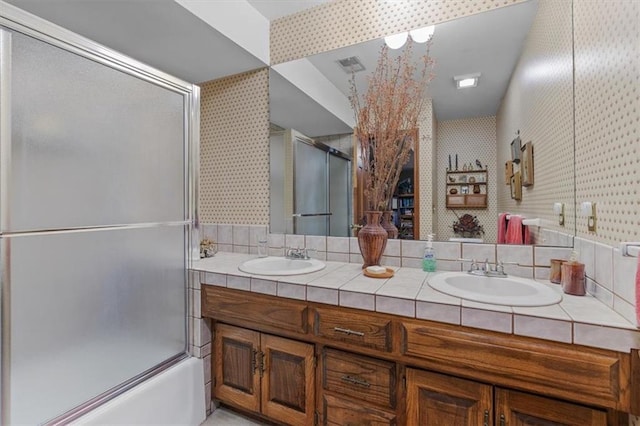 full bathroom featuring double vanity, a sink, visible vents, and wallpapered walls