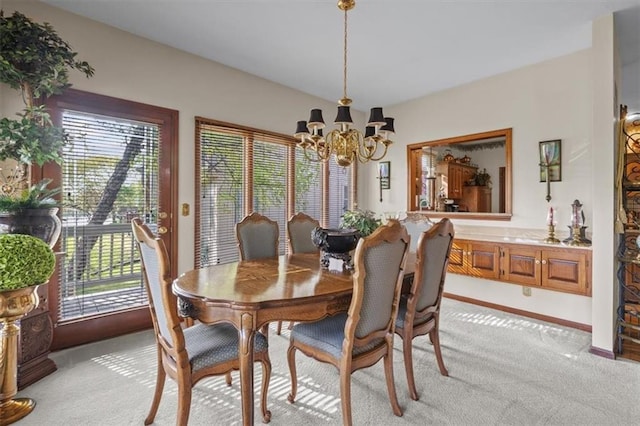 dining area featuring baseboards, a chandelier, and light colored carpet