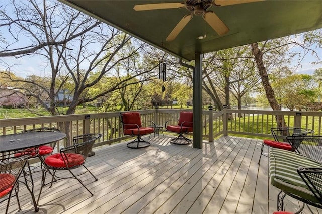 wooden deck with a ceiling fan and outdoor dining space