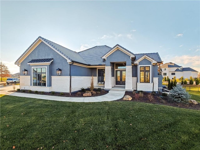 modern farmhouse style home with stucco siding, a front yard, and a tiled roof