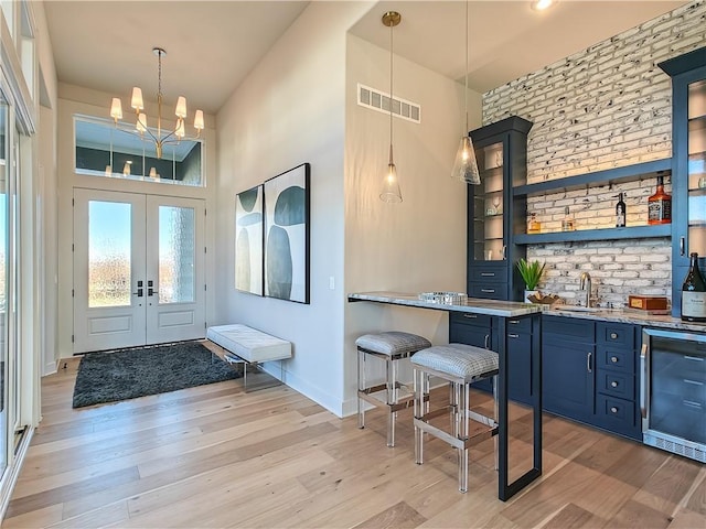 entryway featuring indoor wet bar, beverage cooler, visible vents, and light wood-type flooring