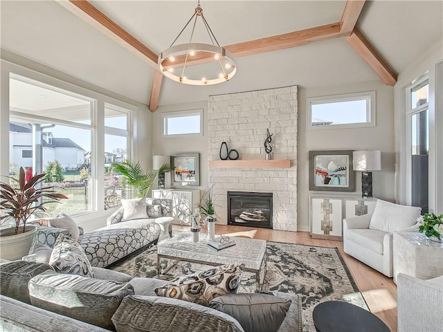 living area featuring lofted ceiling with beams, an inviting chandelier, wood finished floors, and a fireplace