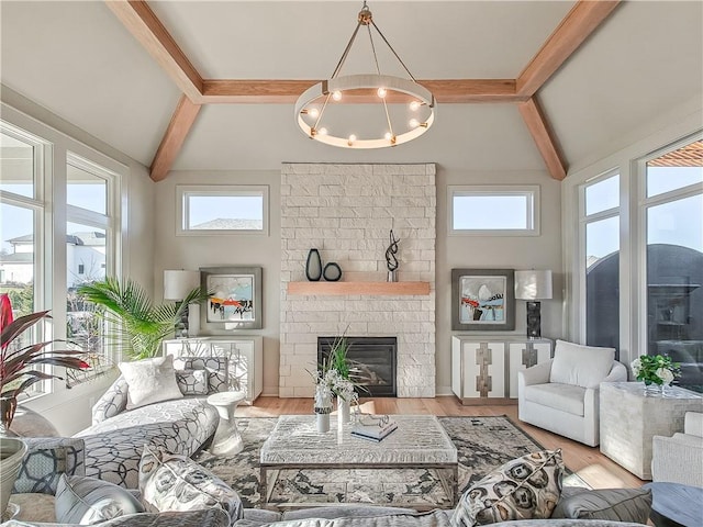 living room with plenty of natural light, a fireplace, vaulted ceiling with beams, and wood finished floors