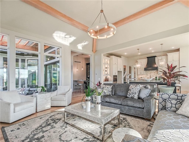 living room with crown molding, a notable chandelier, and light wood-style floors