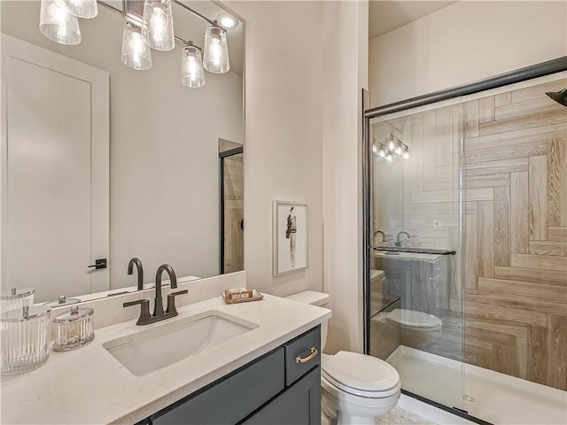 bathroom with vanity, toilet, and a stall shower