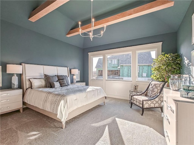 bedroom featuring lofted ceiling, carpet floors, and an inviting chandelier