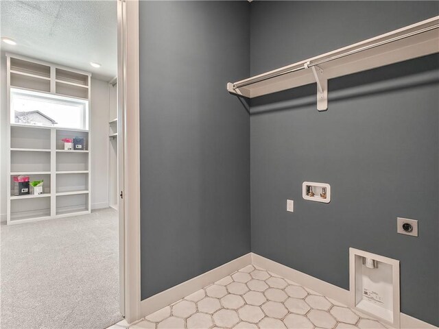 laundry room featuring baseboards, laundry area, hookup for a washing machine, electric dryer hookup, and a textured ceiling