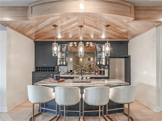 kitchen featuring a kitchen island, backsplash, a breakfast bar area, light wood finished floors, and wood ceiling