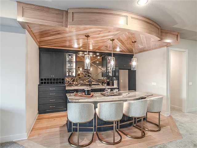 bar with light wood-style floors, decorative light fixtures, wood ceiling, and baseboards