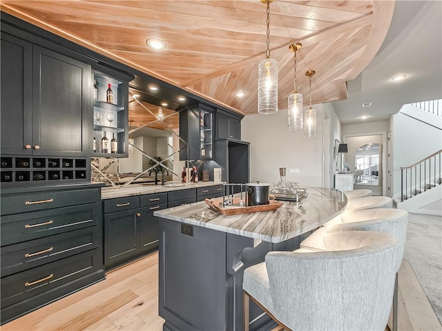 kitchen featuring open shelves, light wood-style floors, a breakfast bar area, wood ceiling, and hanging light fixtures