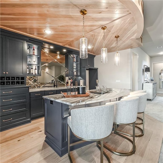 kitchen featuring open shelves, wood ceiling, light stone countertops, and light wood-style floors