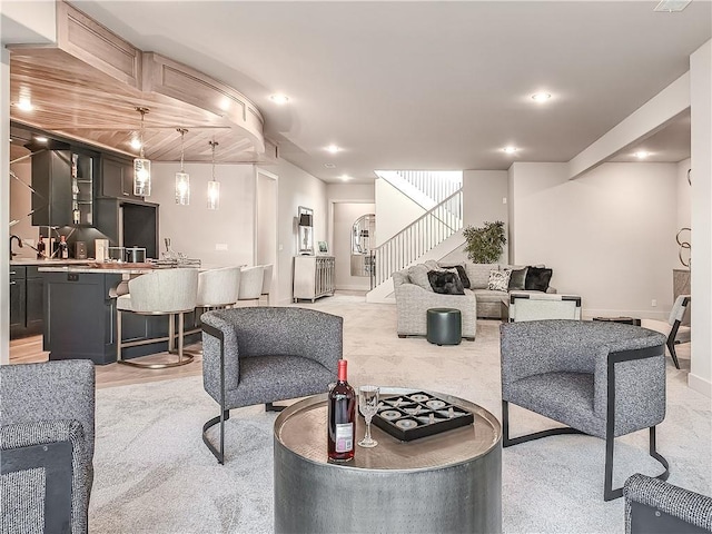 living area with stairway, recessed lighting, and light colored carpet