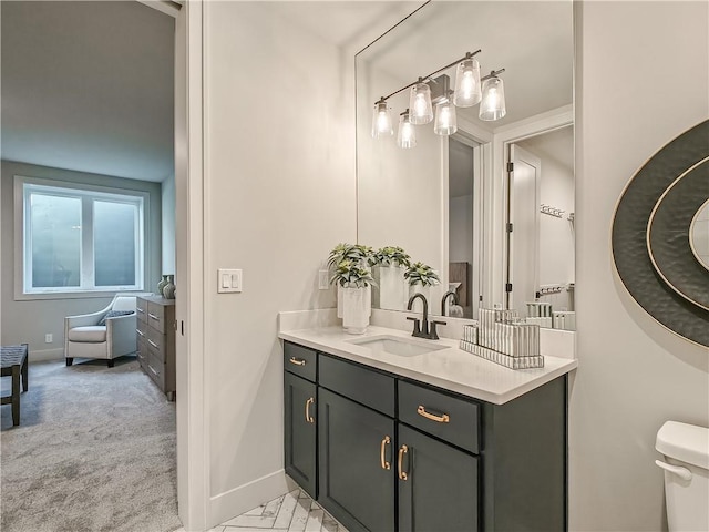 bathroom with vanity, toilet, and baseboards