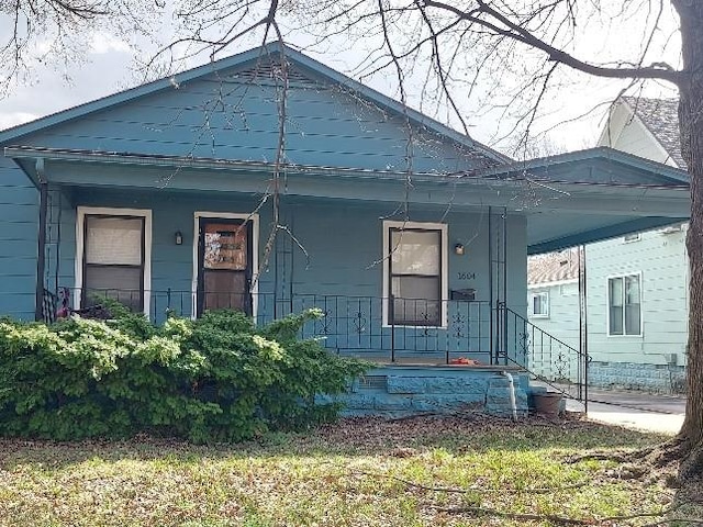 bungalow-style home featuring an attached carport and a porch