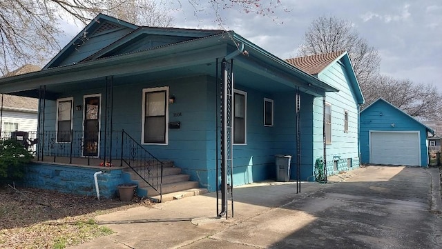 view of front of house featuring a porch, an outbuilding, a garage, and driveway