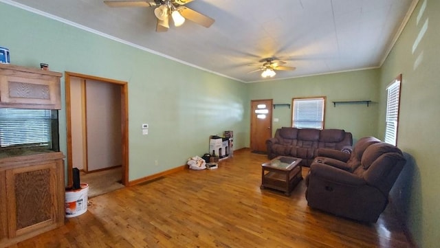 living room featuring wood finished floors, a ceiling fan, and ornamental molding