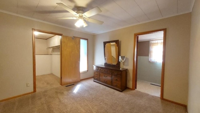 unfurnished bedroom with a closet, visible vents, a walk in closet, and carpet floors