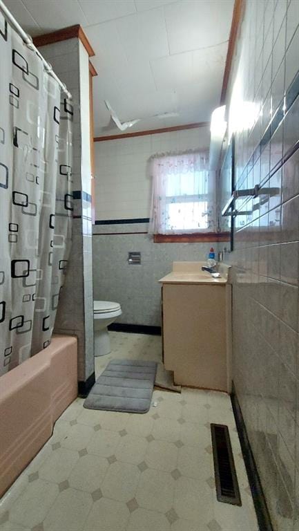 bathroom featuring visible vents, tile walls, toilet, tile patterned floors, and vanity