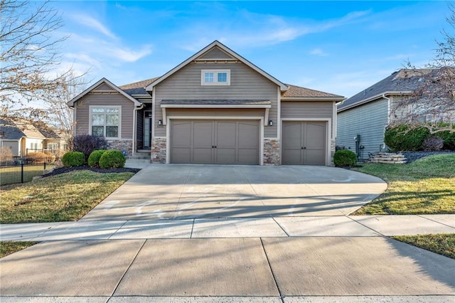 craftsman-style home featuring a garage, stone siding, concrete driveway, and fence