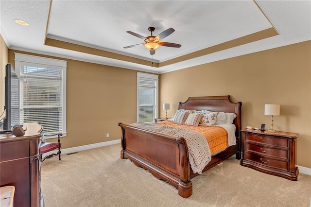 bedroom featuring a tray ceiling, baseboards, light colored carpet, and ornamental molding