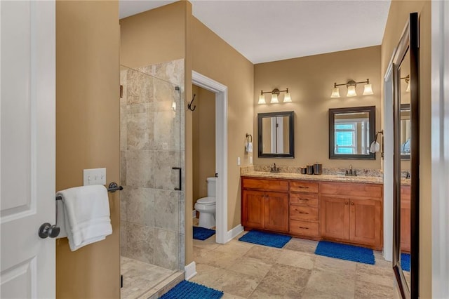 bathroom featuring toilet, a stall shower, a sink, double vanity, and baseboards