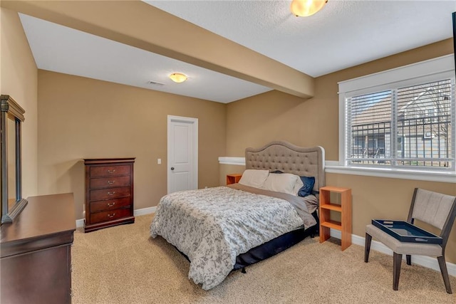 bedroom featuring visible vents, carpet, baseboards, beam ceiling, and a textured ceiling