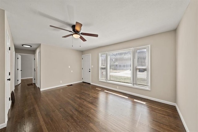 unfurnished room with a ceiling fan, wood finished floors, and baseboards