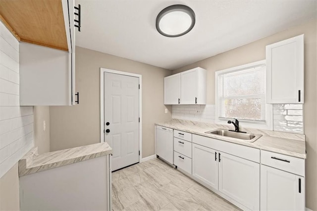 kitchen featuring a sink, decorative backsplash, white cabinets, and white dishwasher