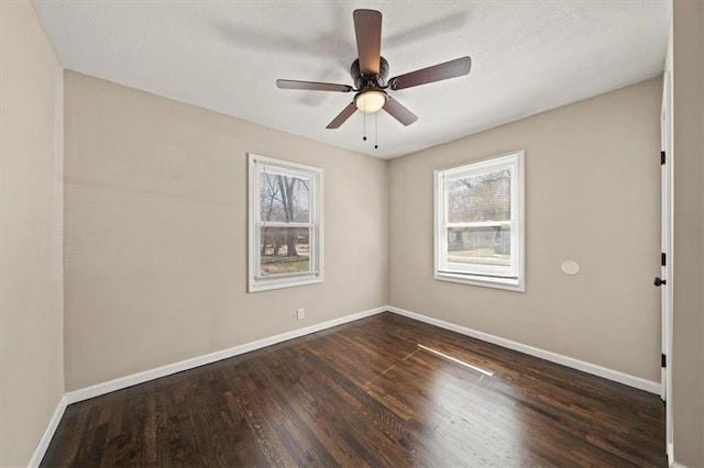 unfurnished room featuring a healthy amount of sunlight, ceiling fan, baseboards, and wood finished floors