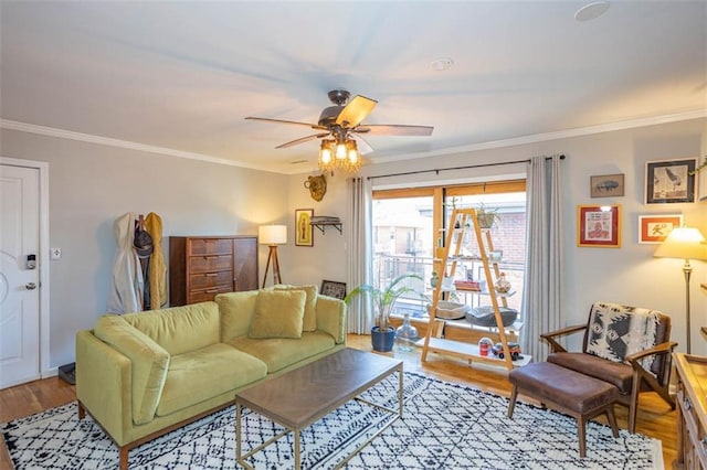 living room featuring wood finished floors, a ceiling fan, and ornamental molding