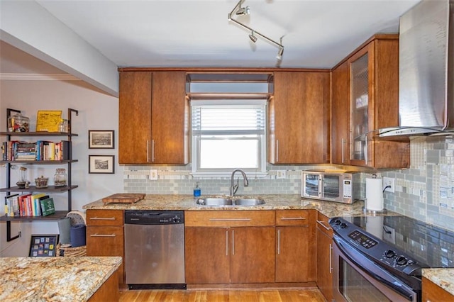 kitchen with brown cabinets, a sink, stainless steel dishwasher, black range with electric cooktop, and wall chimney exhaust hood