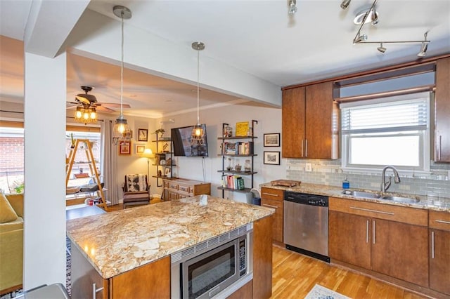 kitchen featuring a sink, stainless steel appliances, and brown cabinetry