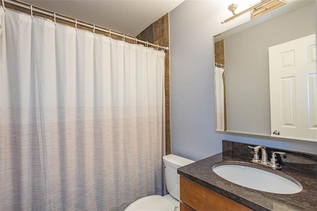 full bathroom featuring a shower with shower curtain, toilet, and vanity