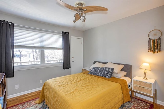 bedroom featuring ceiling fan, baseboards, and wood finished floors