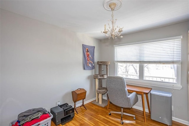 home office with baseboards, an inviting chandelier, and wood finished floors