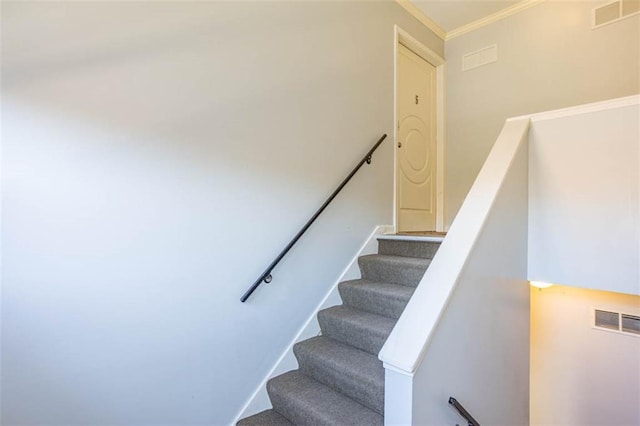 stairway with visible vents, baseboards, and ornamental molding