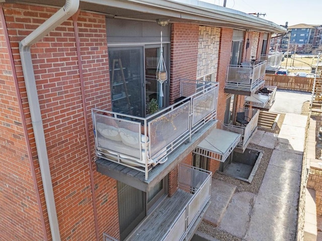 view of property exterior featuring fence and brick siding