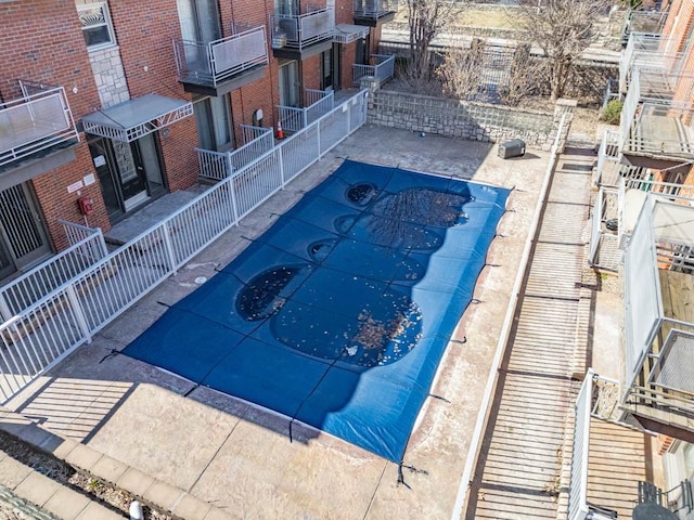 view of pool with a jacuzzi and fence