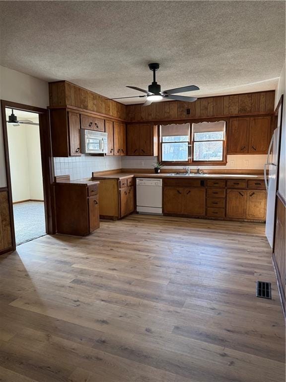 kitchen with white appliances, light wood-type flooring, and a ceiling fan