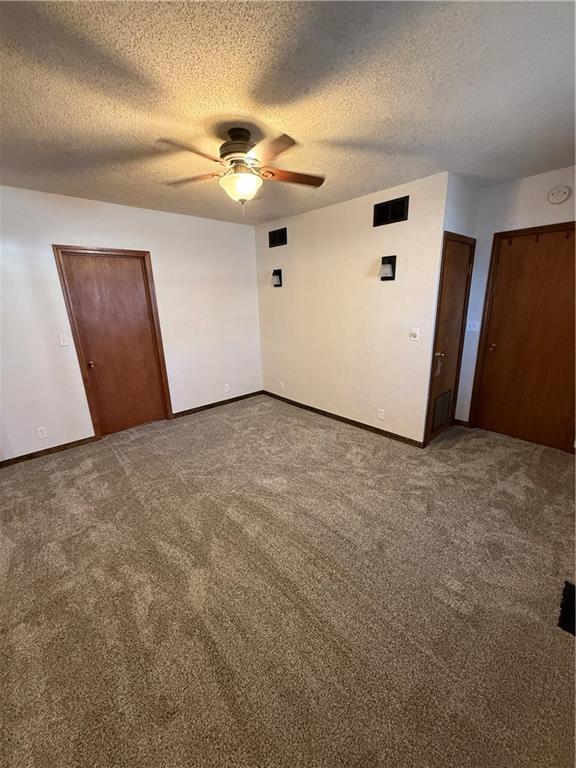 unfurnished bedroom featuring carpet flooring, visible vents, and a textured ceiling