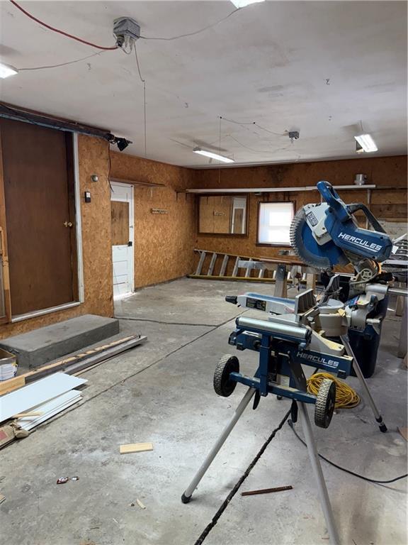 misc room with a garage and concrete flooring