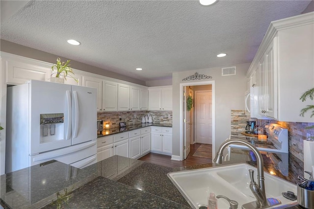 21212 E 52nd Street Ct, Blue Springs, MO 64015 - kitchen with freestanding refrigerator, visible vents, and white cabinetry