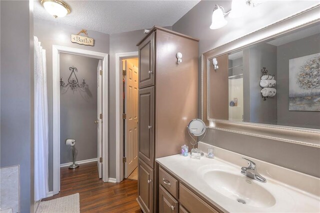 21212 E 52nd Street Ct, Blue Springs, MO 64015 - bathroom featuring baseboards, vanity, wood finished floors, and a textured ceiling