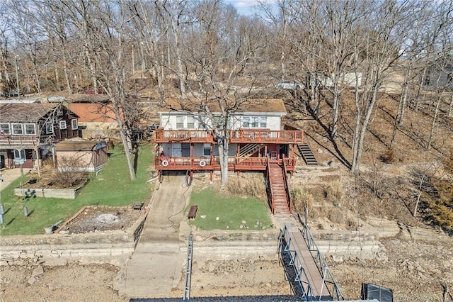 exterior space featuring stairs, a deck, and a front lawn