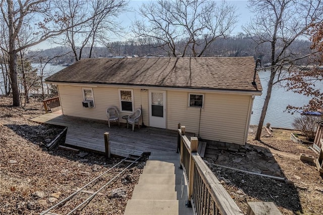 back of property with cooling unit, roof with shingles, and a wooden deck