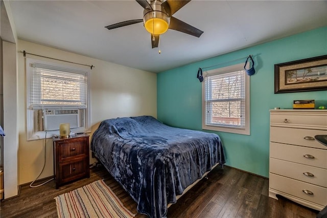 bedroom with cooling unit, dark wood finished floors, and a ceiling fan