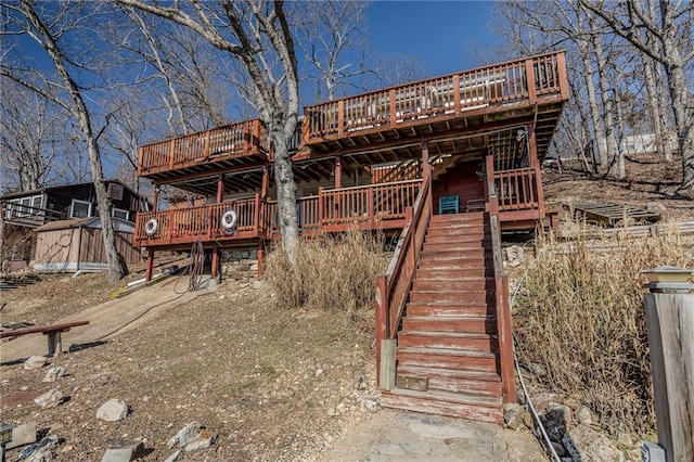 back of property featuring stairway and a wooden deck