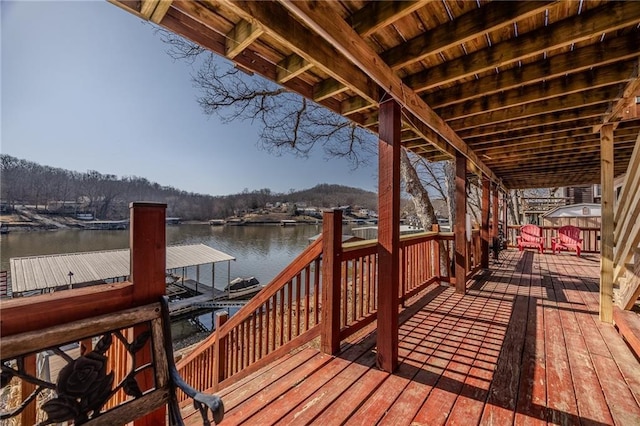 wooden deck with a dock and a water view